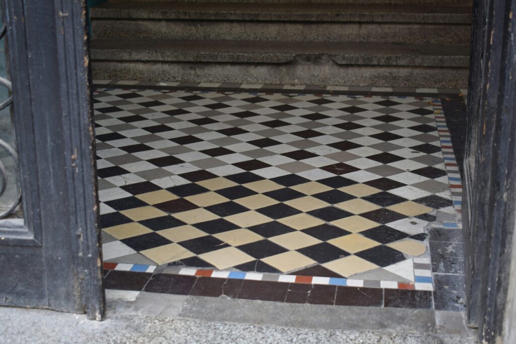 An old tile floor with discoloration from use