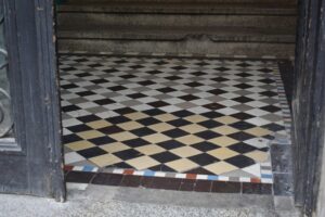 An old tile floor with discoloration from use