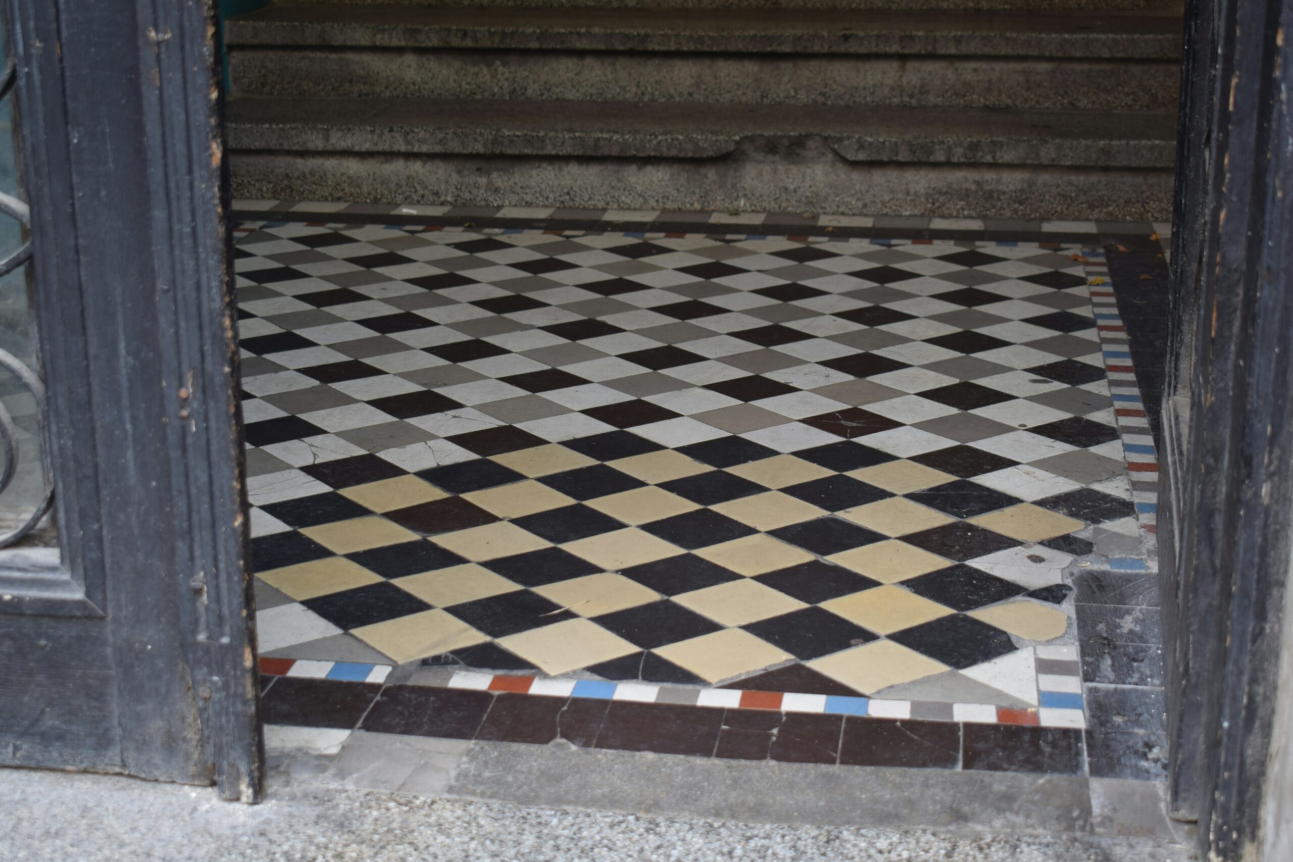 An old tile floor with discoloration from use